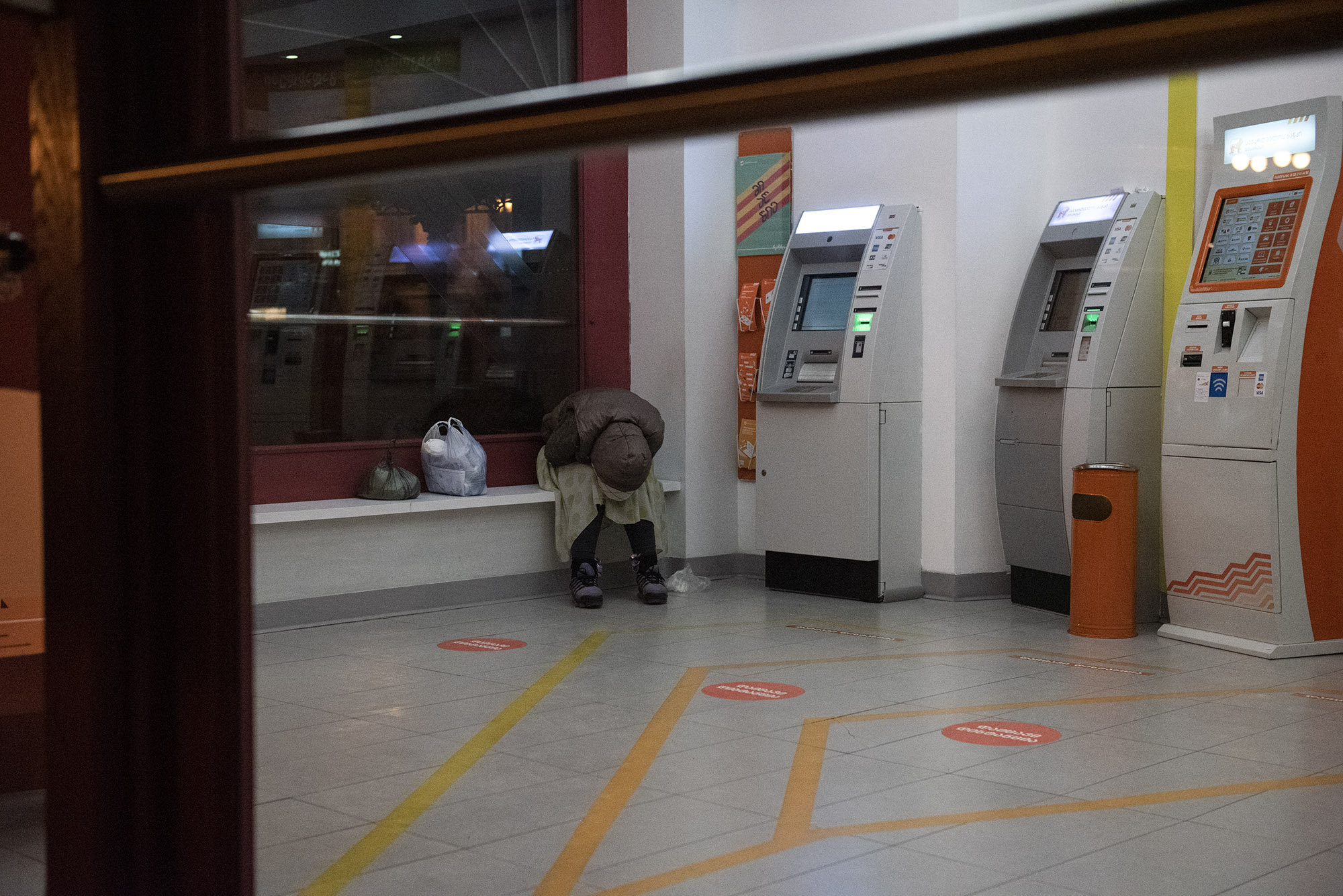 A woman sleeps inside a Bank of Georgia ATM area on 31 March. Photo: Mariam Nikuradze/OC Media. 