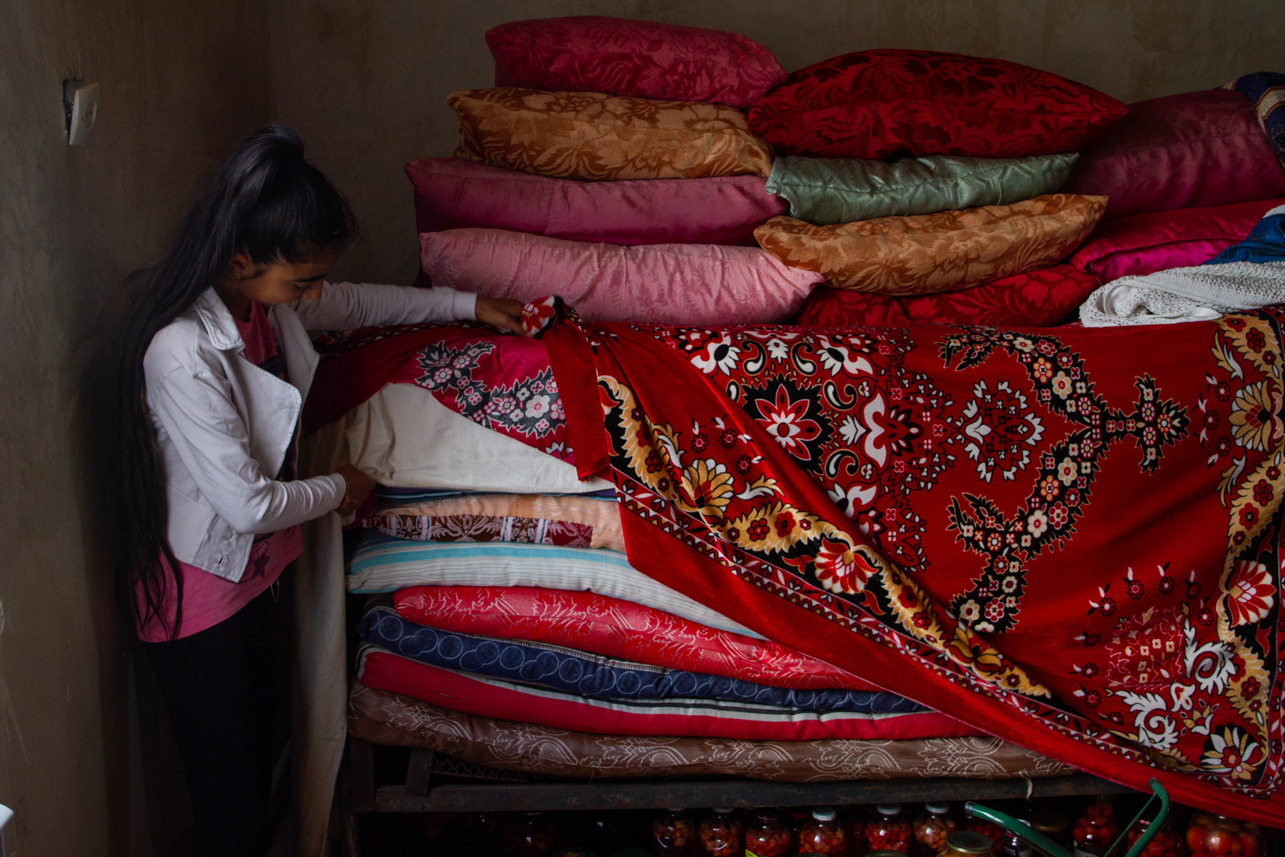 Maya shows off the traditional mattresses of their house, which Yazidi families are proud of. Photo: Hermine Virabian/OC Media.